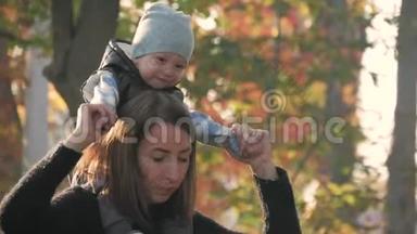 妈妈在一个秋天的公园里围着一个小儿子转。 秋天公园的<strong>幸福家庭</strong>。 慢生活中的<strong>幸福家庭</strong>